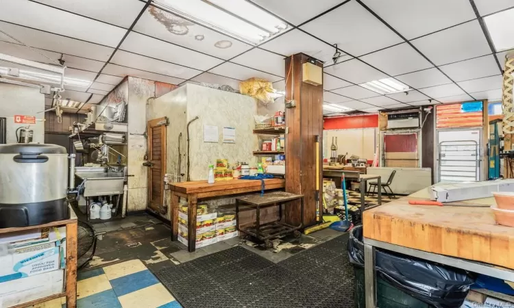 Miscellaneous room with a drop ceiling, sink, and a workshop area