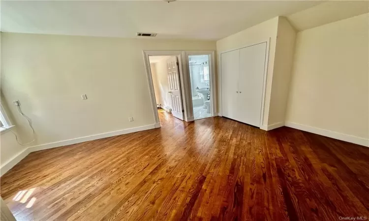 Unfurnished entry room to upstairs that can be used as a bedroom with closet, office or sitting room -  access to full bathroom with additional 2 bedrooms one on  each side, and wood-type flooring