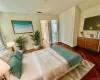 Virtually Staged - Upstairs center room staged as Bedroom 3 - featuring connected bathroom, additional 2 bedrooms are accessed from this room. Dark wood-type flooring, and a closet