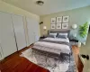 Virtually Staged - Upstairs Bedroom 1  with multiple closets and hardwood / wood-style floors