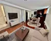 Virtually Staged Lower Level - Staged as Family room with open concept kitchen, featuring wood-type flooring, a textured ceiling, and a full bathroom with stacked washer / dryer