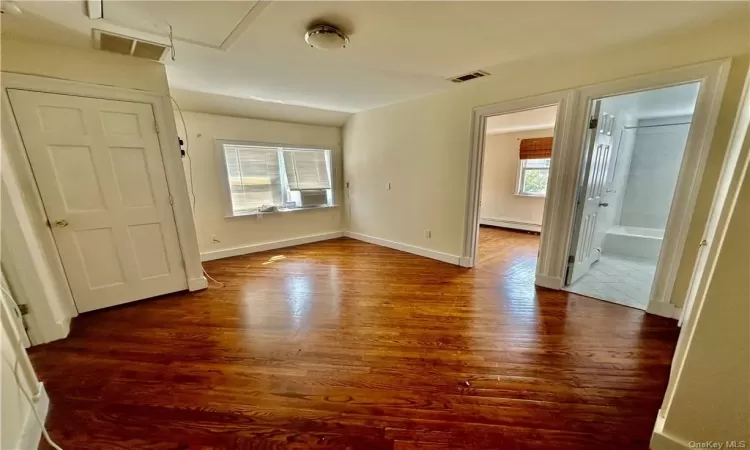 Unfurnished entry room to upstairs that can be used as a bedroom with closet, office or sitting room -  access to full bathroom with additional 2 bedrooms one on  each side, and wood-type flooring