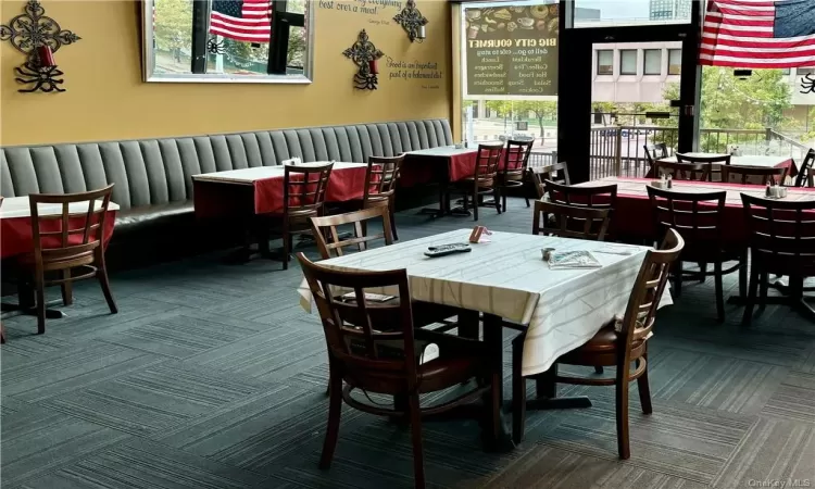 Dining space with plenty of natural light and carpet