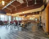 Dining area with a towering ceiling, brick wall,/ wood-style flooring, and rail lighting