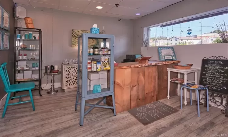 Bar with hardwood / wood-style floors and a drop ceiling