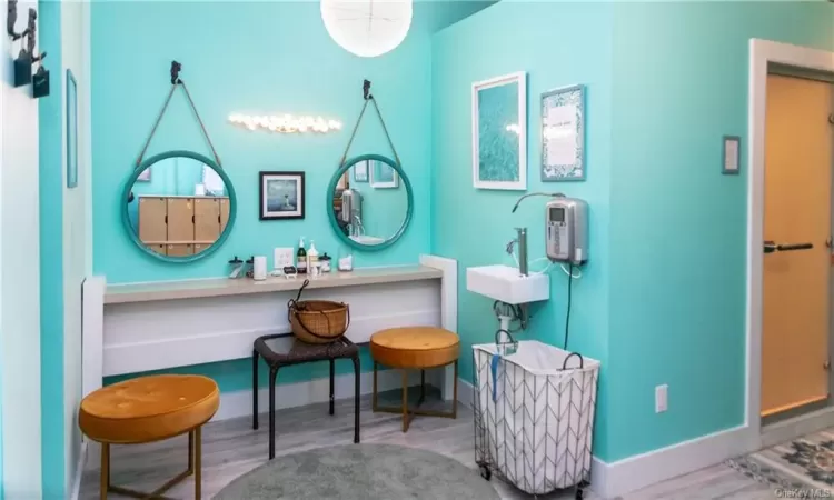 Vanity area and locker area with steam room and sauna, showers and rest room