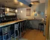 Bar featuring hanging light fixtures and light hardwood / wood-style floors