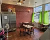 Tiled dining room with ceiling fan and brick wall