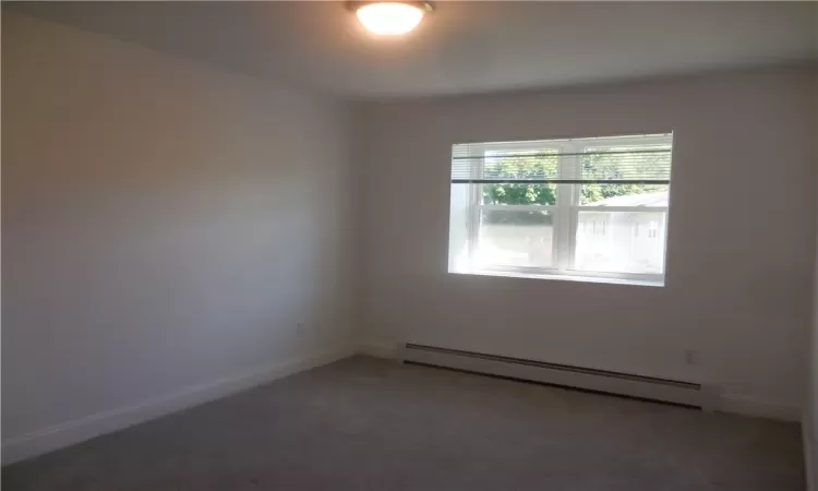 Carpeted empty room with baseboard heating