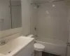 Full bathroom with vanity, tiled shower / bath combo, toilet, and tile patterned floors