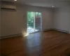 Spare room featuring a wall mounted AC, a baseboard radiator, and dark wood-type flooring