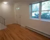 Foyer entrance featuring hardwood / wood-style flooring, a baseboard heating unit, and plenty of natural light