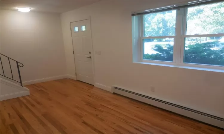 Foyer entrance featuring hardwood / wood-style flooring, a baseboard heating unit, and plenty of natural light