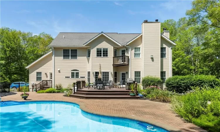 View of swimming pool featuring a patio and a wooden deck