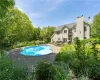 Back of house featuring a balcony and a pool side deck