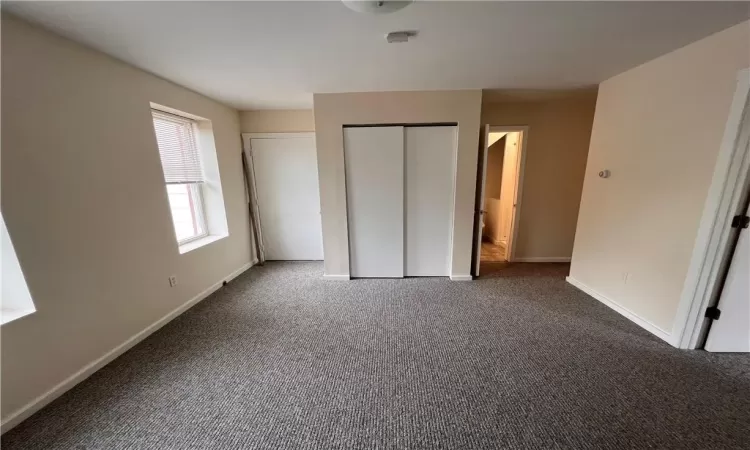 Unfurnished bedroom featuring a closet and carpet floors