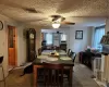 Dining area with ceiling fan, a textured ceiling, and carpet