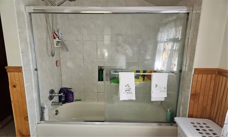 Bathroom with combined bath / shower with glass door