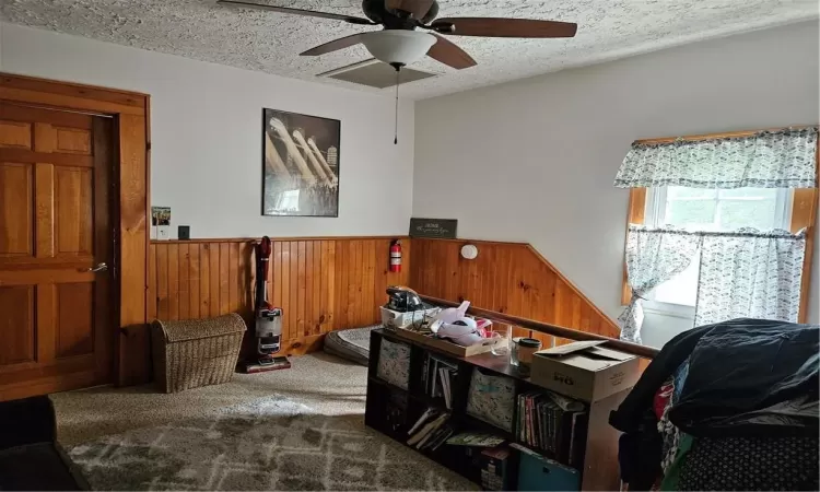 Top of Staircase with a textured ceiling, ceiling fan, and carpet floors