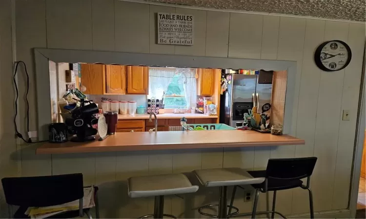 Kitchen with a breakfast bar and fridge