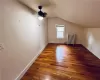 Additional living space featuring radiator heating unit, vaulted ceiling, ceiling fan, and dark hardwood / wood-style flooring