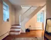 Stairs with ornamental molding, hardwood / wood-style floors, and a baseboard radiator