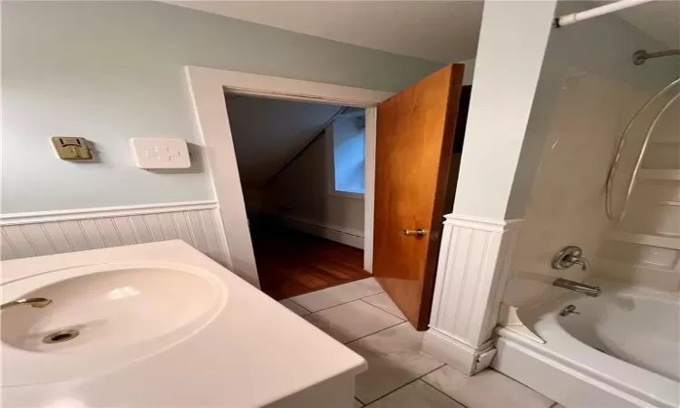 Bathroom with tile patterned flooring, baseboard heating, shower / tub combination, and vanity