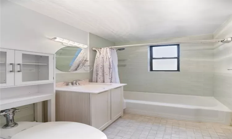 Full bathroom with vanity, tile patterned floors, toilet, and shower / bathtub combination with curtain