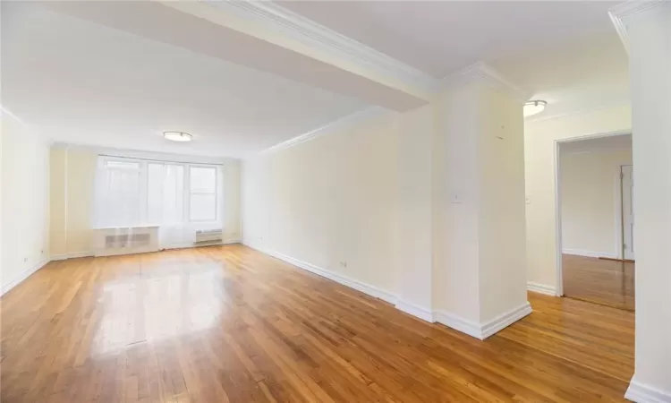 Unfurnished room with radiator, and wood flooring