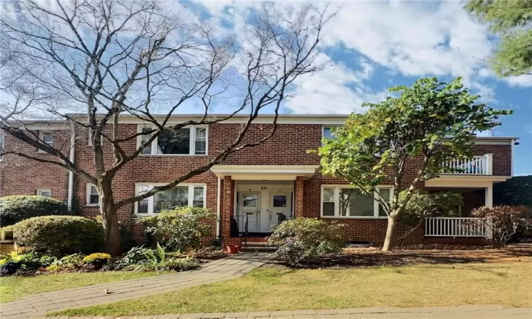 View of front of home featuring a balcony and a front yard