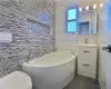 Bathroom featuring tile walls and a washtub