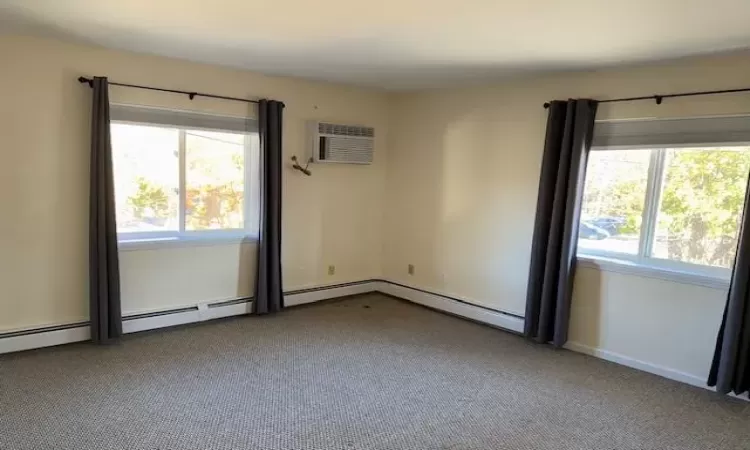 Carpeted empty room with a wall mounted air conditioner