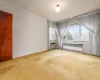 Unfurnished room with carpet flooring and radiator heating unit