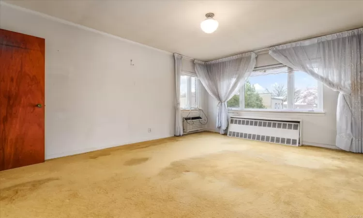 Unfurnished room with carpet flooring and radiator heating unit