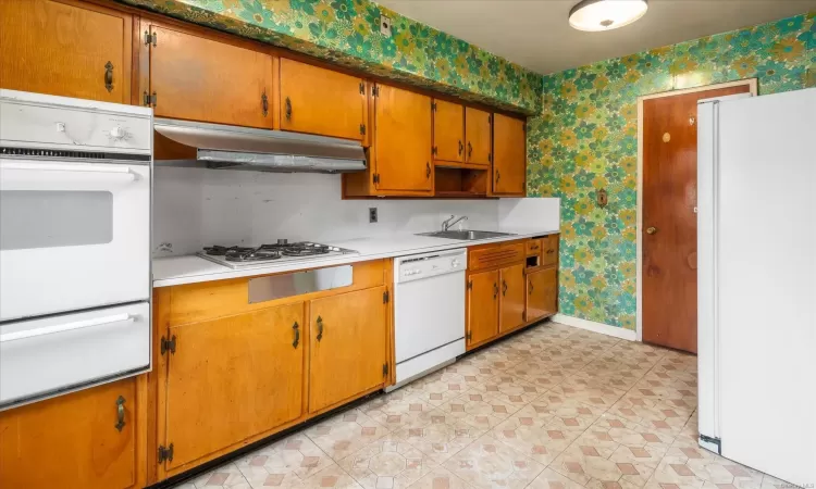 Kitchen featuring white appliances and sink