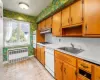 Kitchen featuring white appliances, sink, and radiator