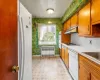 Kitchen with white appliances, radiator, and sink