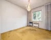 Empty room with a chandelier, radiator heating unit, heating unit, and carpet