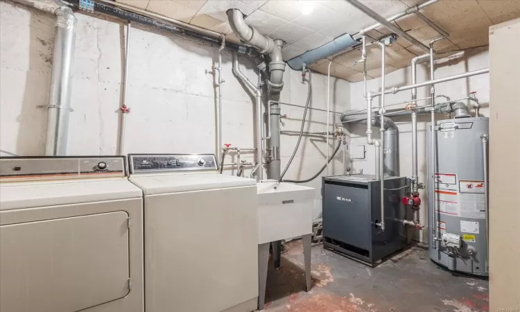 Laundry room featuring water heater and washer and clothes dryer