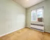 Unfurnished room with radiator and carpet floors