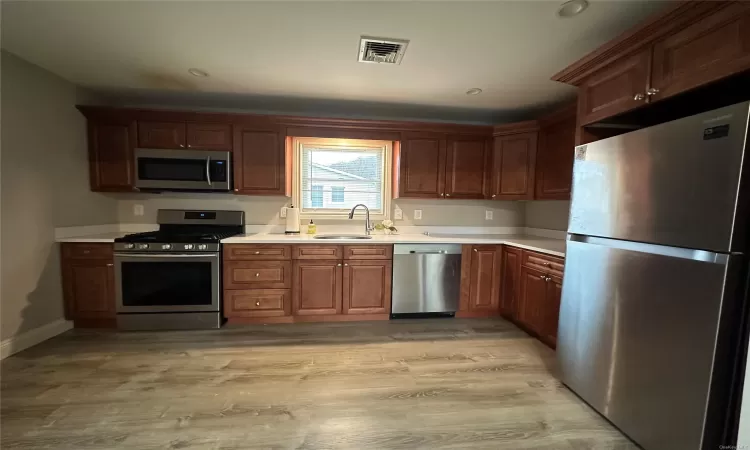 Kitchen with sink, stainless steel appliances, and light hardwood / wood-style flooring