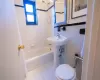 Bathroom with tile patterned flooring, shower / tub combo, tile walls, and toilet