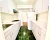 Kitchen featuring white fridge, white cabinets, gas stovetop, and sink