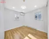 Unfurnished room featuring light wood-type flooring, a wall mounted AC, and a baseboard heating unit