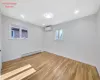 Spare room with a baseboard radiator, a wall unit AC, and light hardwood / wood-style flooring