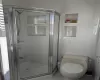 Bathroom featuring tile patterned floors, toilet, and an enclosed shower