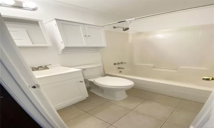 Full bathroom with shower / washtub combination, crown molding, tile patterned flooring, and toilet