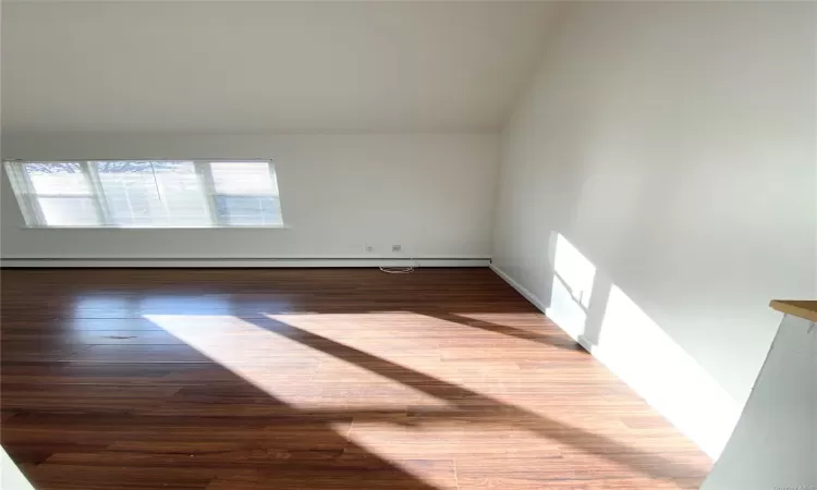 Spare room featuring hardwood / wood-style floors and a baseboard heating unit