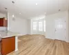 Kitchen with kitchen peninsula, hanging light fixtures, and light wood-type flooring