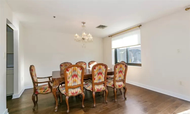 Dining area featuring a notable chandelier and dark hardwood / wood-style floors